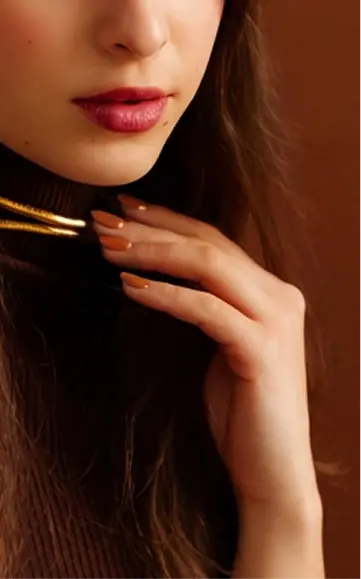 Woman with Orange No. 2 nails holding a makeup brush